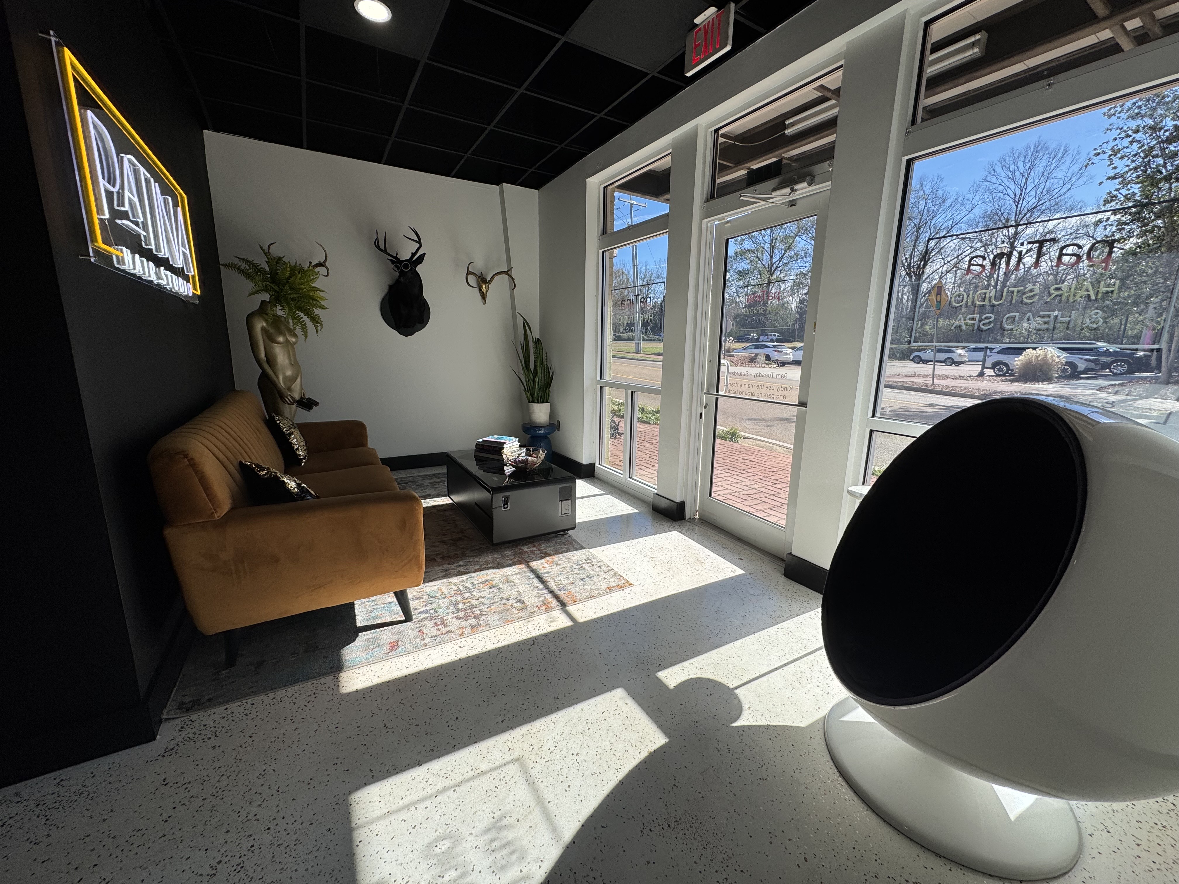 Patina Hair Studio waiting area with neon sign